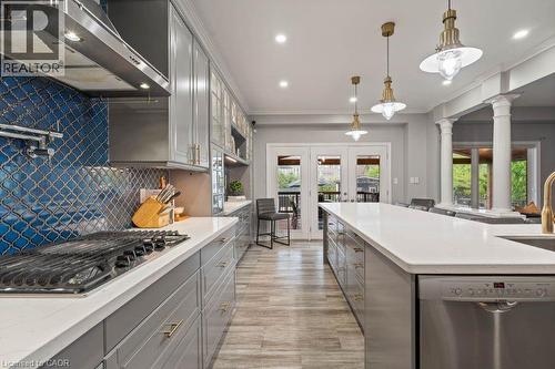 Kitchen with appliances with stainless steel finishes, under cabinet range hood, gray cabinetry, french doors, and healthy amount of natural light - 151 Fair Street, Ancaster, ON 