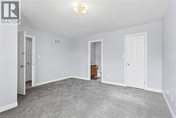 Unfurnished bedroom featuring carpet flooring, connected bathroom, and a textured ceiling - 
