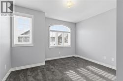 Empty room featuring dark carpet and healthy amount of natural light - 