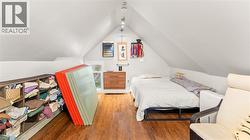 Bedroom featuring wood finished floors and vaulted ceiling - 