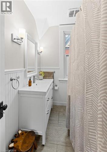 Bathroom with vanity, lofted ceiling, a shower with shower curtain, and wainscoting - 58 Hohner Avenue, Kitchener, ON - Indoor Photo Showing Bathroom