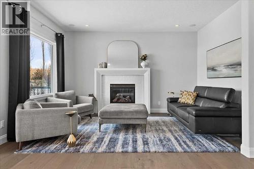 Main floor living area - 255 Gleneagles View, Cochrane, AB - Indoor Photo Showing Living Room With Fireplace