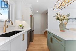 Bright & modern design with quartz countertop & backsplash, contrasting island, pot-filler, and stainless steel appliances. - 