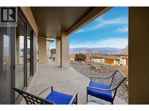 Covered lower-level patio features wood soffits, exposed aggregate - 468 Sparrow Hawk Court, Kelowna, BC - Outdoor With Deck Patio Veranda With Exterior