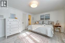 Bedroom with crown molding and light wood-style flooring - 