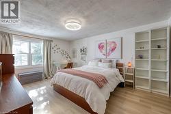 Bedroom with light wood-style floors and a textured ceiling - 