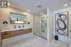 Bathroom with vanity, a marble finish shower, recessed lighting, and light marble finish flooring - 