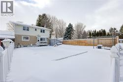 Snow covered rear of property with a storage shed - 