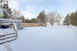 Yard layered in snow with a fenced backyard - 