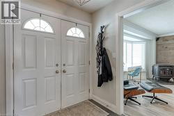 Entryway with a textured ceiling, wood finished floors, a wood stove, wooden walls, and ornamental molding - 