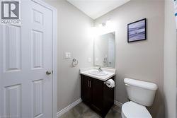 Half bath with vanity and dark tile patterned flooring - 
