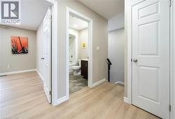 Hall with light wood-style flooring and recessed lighting - 