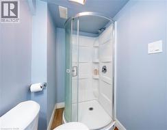 Bathroom with a shower stall and wood finished floors - 