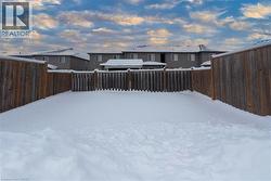 Yard layered in snow featuring a fenced backyard - 