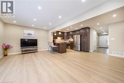 Living room with light wood-style flooring and recessed lighting - 