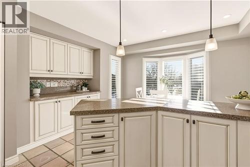 Kitchen with hanging light fixtures, backsplash, light tile patterned flooring, recessed lighting, and cream cabinets - 1489 Litchfield Road, Oakville, ON - Indoor Photo Showing Kitchen