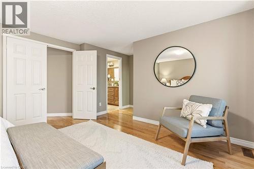 Bedroom with ensuite bath, light wood-style flooring, and a textured ceiling - 1489 Litchfield Road, Oakville, ON - Indoor