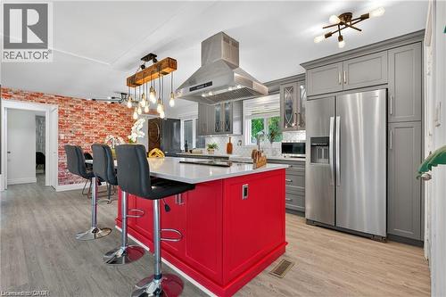 Kitchen with appliances with stainless steel finishes, glass insert cabinets, island exhaust hood, hanging light fixtures, and light wood finished floors - 146 Appalachian Crescent Unit# Upper, Kitchener, ON - Indoor Photo Showing Kitchen