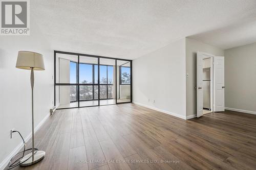 Living Room Features Engineered Hardwood Flooring - 702 - 1240 Marlborough Court, Oakville, ON - Indoor Photo Showing Other Room