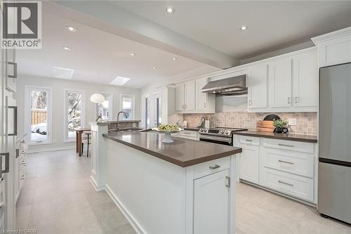 Kitchen featuring appliances with stainless steel finishes, white cabinets, a center island with sink, wall chimney exhaust hood, and recessed lighting - 4226 Dunvegan Road, Burlington, ON - Indoor Photo Showing Kitchen With Upgraded Kitchen