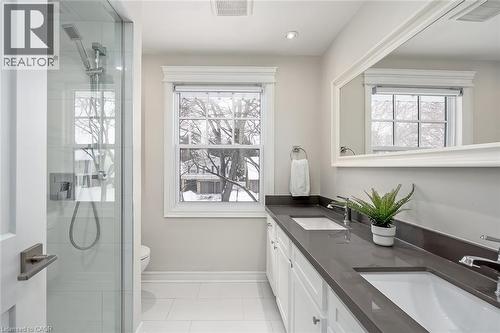 Bathroom featuring double vanity, a shower stall, and light tile patterned floors - 4226 Dunvegan Road, Burlington, ON - Indoor Photo Showing Bathroom