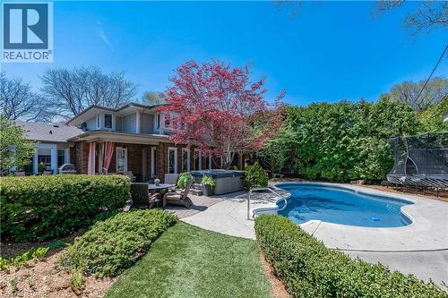 Outdoor pool with a hot tub, a trampoline, and a patio - 4226 Dunvegan Road, Burlington, ON - Outdoor With In Ground Pool With Deck Patio Veranda
