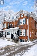 View of front of home featuring brick siding and a balcony - 