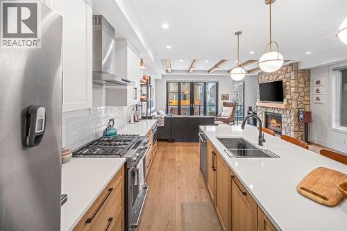 4, 810 3Rd Street, Canmore, AB - Indoor Photo Showing Kitchen With Fireplace With Double Sink