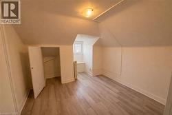 Bonus room with light wood-style floors and vaulted ceiling - 