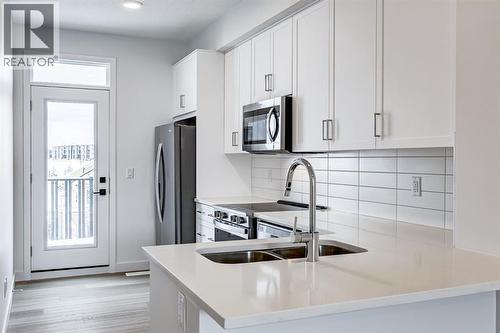 202, 437 Alpine Avenue Sw, Calgary, AB - Indoor Photo Showing Kitchen With Double Sink With Upgraded Kitchen