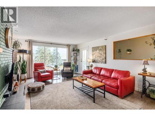Take note of the expansive front window to enjoy the view of the mountains - 865 Theodora Road, Kelowna, BC - Indoor Photo Showing Living Room With Fireplace