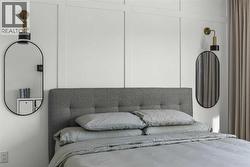 The primary suite is anchored by a striking feature wall with ambient lighting, creating a warm and inviting space - 