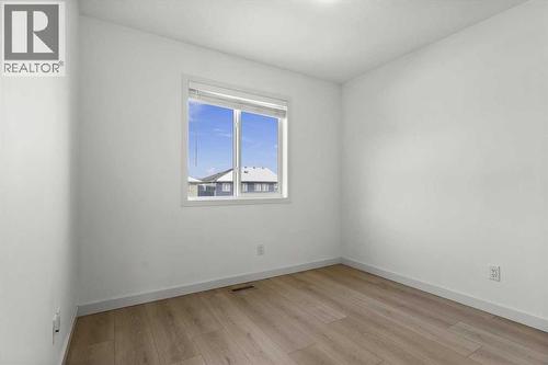 The third upper-level bedroom offers a versatile layout suitable for family living or a home office - 59 Wolf Hollow Way Se, Calgary, AB - Indoor Photo Showing Other Room