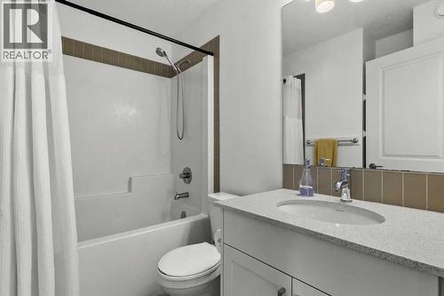 The shared upper-level bathroom features a clean, functional design with neutral finishes and a full tub-shower combination - 59 Wolf Hollow Way Se, Calgary, AB - Indoor Photo Showing Bathroom