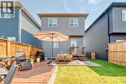 In warmer months, the backyard transforms into an inviting outdoor living area with a spacious deck and green space - 