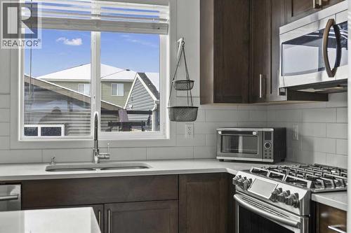 This one even has the coveted kitchen window over the under mount sink! - 59 Wolf Hollow Way Se, Calgary, AB - Indoor Photo Showing Kitchen With Stainless Steel Kitchen With Double Sink With Upgraded Kitchen