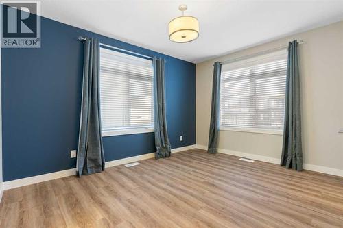 Rear primary bedroom, 2 large windows, vinyl plank flooring - 217 Sage Bluff Drive Nw, Calgary, AB - Indoor