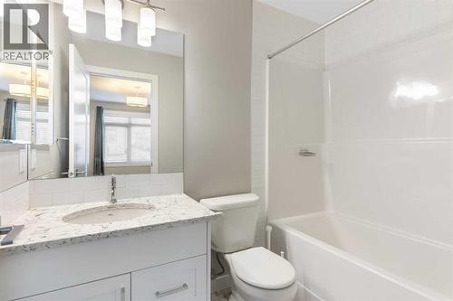 4-piece en-suite, comfort height elongated toilet, ceramic tile floor, granite counter - 217 Sage Bluff Drive Nw, Calgary, AB - Indoor Photo Showing Bathroom