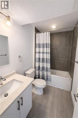 Full bath with vanity, shower / bath combo with shower curtain, and dark wood-type flooring - 228 Margaret Avenue, Kitchener, ON - Indoor Photo Showing Bathroom