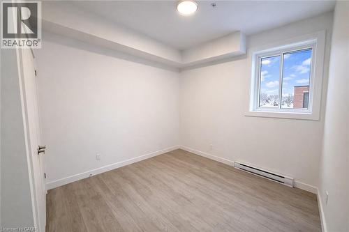 Unfurnished room with a baseboard heating unit, light wood-style flooring, and fire sprinkler in ceiling - 228 Margaret Avenue, Kitchener, ON - Indoor Photo Showing Other Room