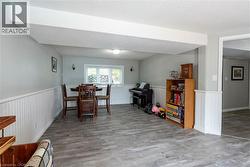 Dining room featuring a textured ceiling, light wood-type flooring, and wainscoting - 