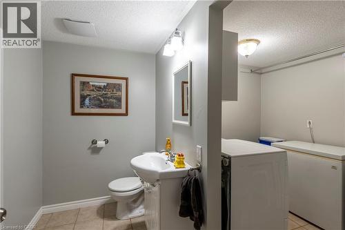 Half bathroom with a textured ceiling, light tile patterned floors, and washing machine and dryer - 29 Armstrong Crescent, Grey Highlands, ON - Indoor