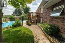 Fenced yard with stairway, a wooden deck, and a patio area - 