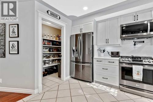 Counter depth SXS Fridge, Stove pot filler - 7 Mountain Park Circle Se, Calgary, AB - Indoor Photo Showing Kitchen