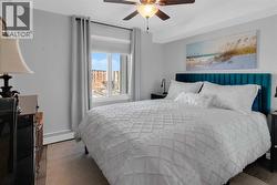 Primary bedroom with ceiling fan and blackout window coverings - 