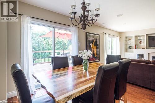 Dining room with a chandelier, wood finished floors, and a glass covered fireplace - 330 Strathcona Drive, Burlington, ON - Indoor Photo Showing Dining Room