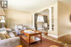 Living area with decorative columns, baseboards, and wood finished floors - 