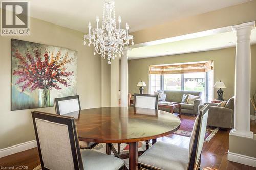 Dining space with ornate columns, wood-type flooring, baseboards, and a chandelier - 330 Strathcona Drive, Burlington, ON - Indoor Photo Showing Dining Room