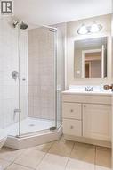 Bathroom featuring a shower stall, tile patterned floors, vanity, and toilet - 