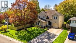 Traditional home featuring stucco siding, driveway, roof with shingles, and a garage - 